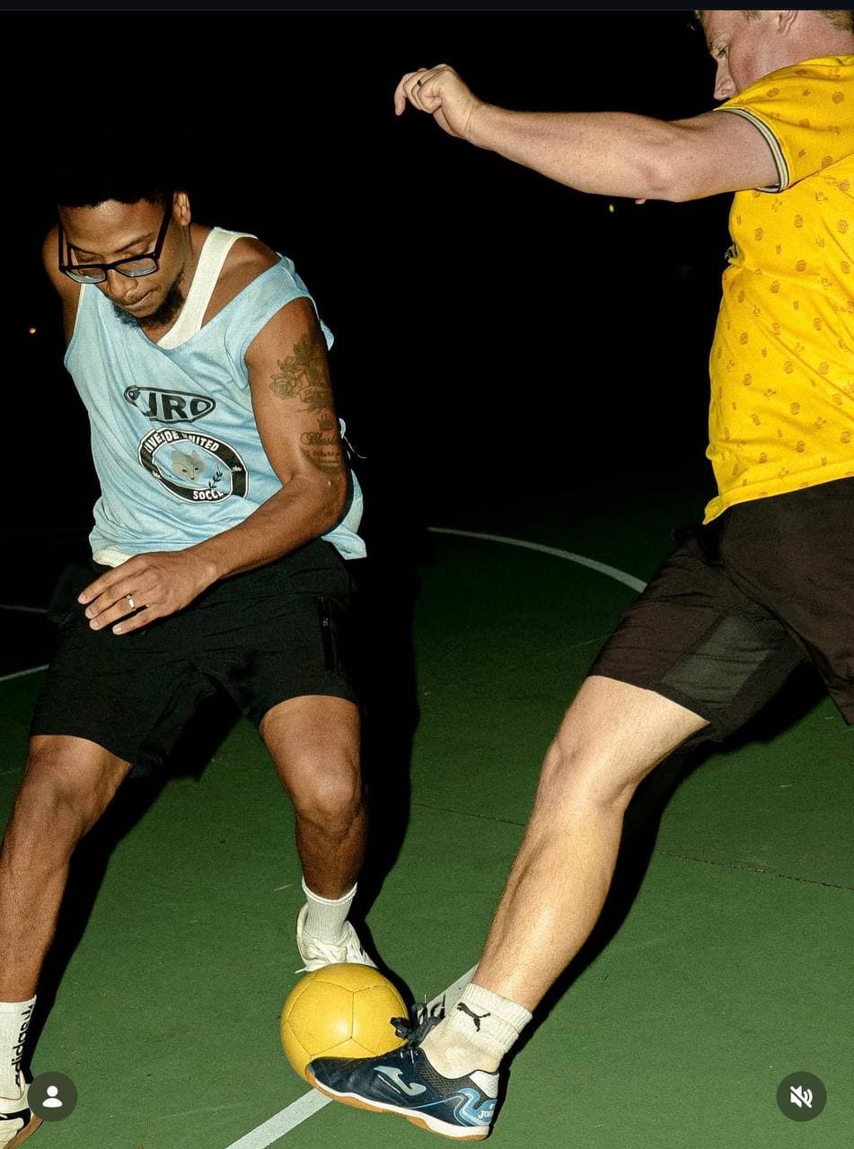 Two players battling for the ball under court lights
