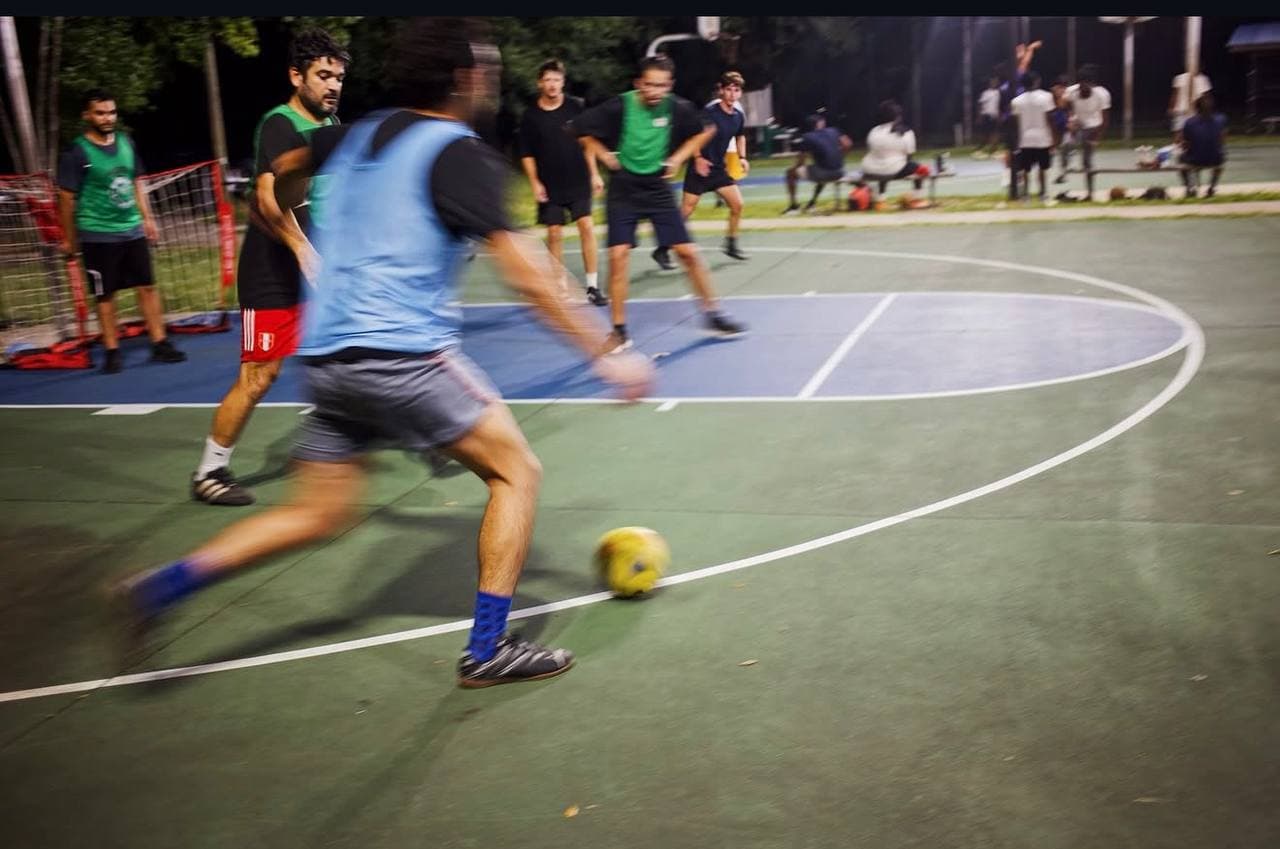 Player driving the ball forward under floodlights