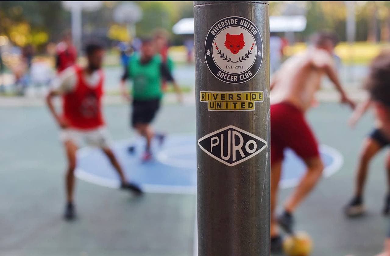 Team stickers on a court pole with players in the background